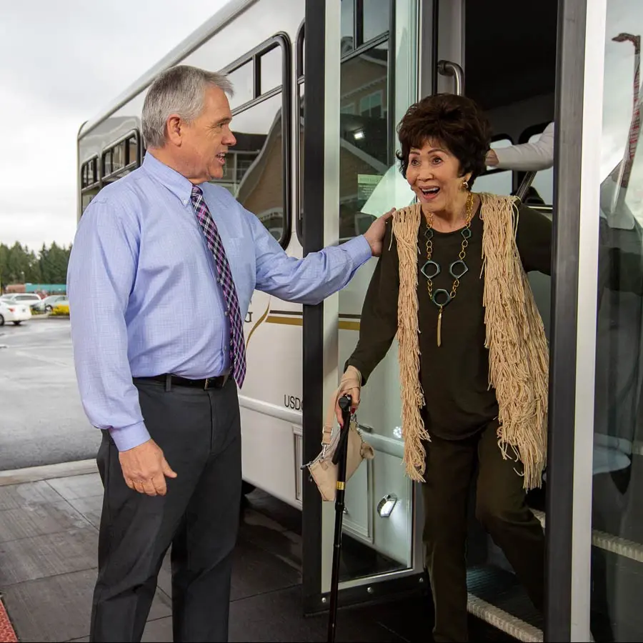 Sycamore Ridge man helping lady off bus