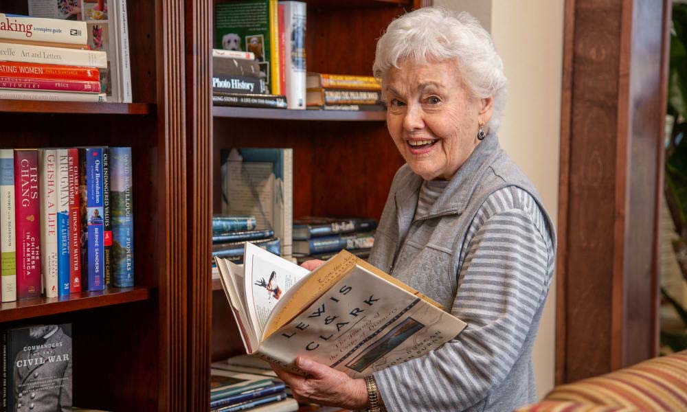 Independent senior near Oakland selecting a book